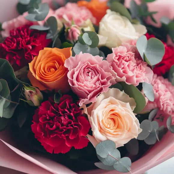 Bouquet of roses and carnations in pink paper
